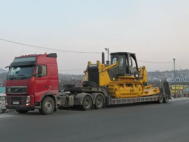 Бульдозер на тралі за тягачем Volvo