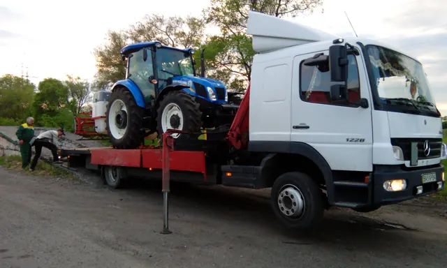 Трактор New Holland на платформі